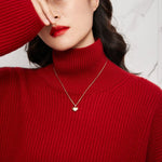 A model wearing Tyche Grace 18K gold heart locket necklace